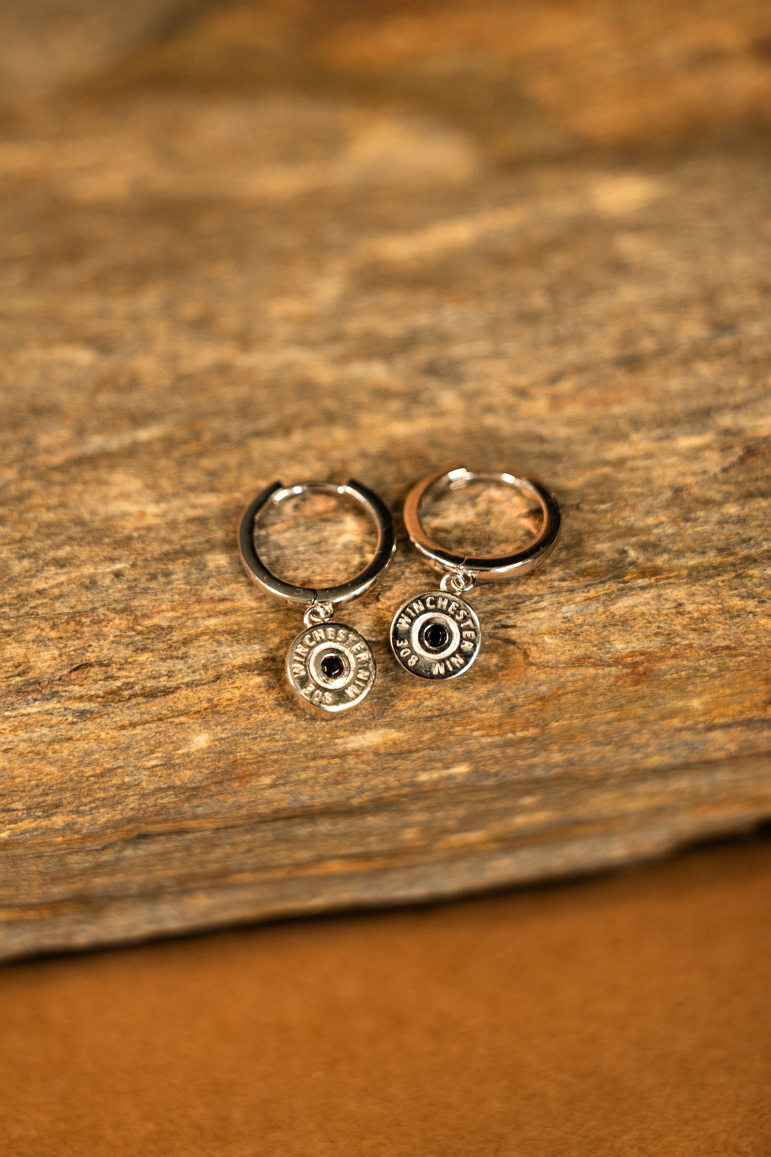 Pair of silver earrings with a winchester bullet pendant
